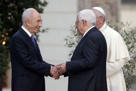 (L-R) Israeli President Shimon Peres shakes hands with Palestinian President Mahmoud Abbas as Pope Francis watches after a prayer meeting at the Vatican June 8, 2014. REUTERS/Max Rossi