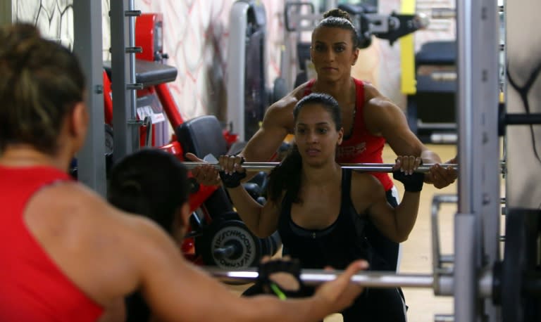 Bahraini female bodybuilder Haifa al-Musawi (background) trains Yemeni-British Shaza Jamil at a gym in Dubai on June 26, 2015