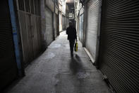 A man walks through closed Tehran's Grand Bazaar, Iran, Saturday, April 10, 2021. Iran on Saturday imposed partial lockdown on businesses in major shopping centers as well as intercity travels through personal cars in major cities including capital Tehran as it struggles with the worst outbreak of the coronavirus in the Mideast region. (AP Photo/Vahid Salemi)