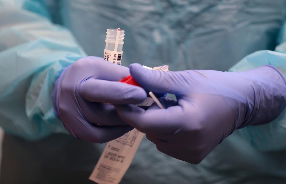 Phlebotomist April Aymong caps prepares a sample to be sent for COVID-19 testing at Salem Health Laboratory in Salem, Oregon on Tuesday, July 12, 2022.