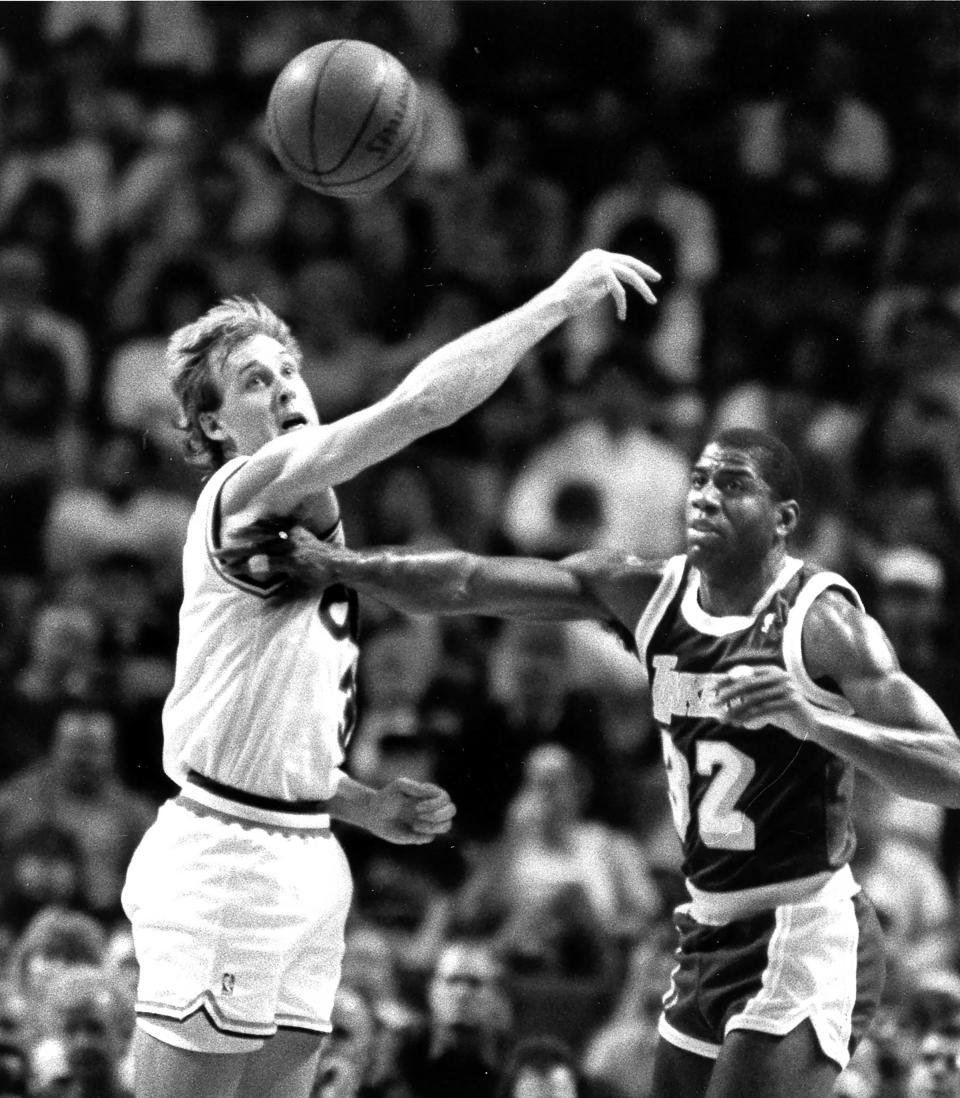 Cleveland Cavaliers guard Craig Ehlo, left, and the Los Angeles Lakers' Magic Johnson eye a loose ball at the Richfield Coliseum, March 15, 1990, in Richfield, Ohio.