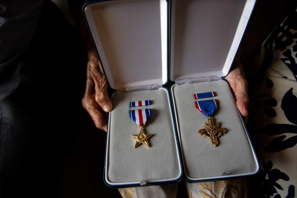 The Silver Star and Distinguished Service Cross are held by Mary Tyndall Troff Tuesday, Aug. 16, 2022, in Holland. The awards, belonging to WWI combat pilot Frank Tyndall, were returned to the family after being stolen.
