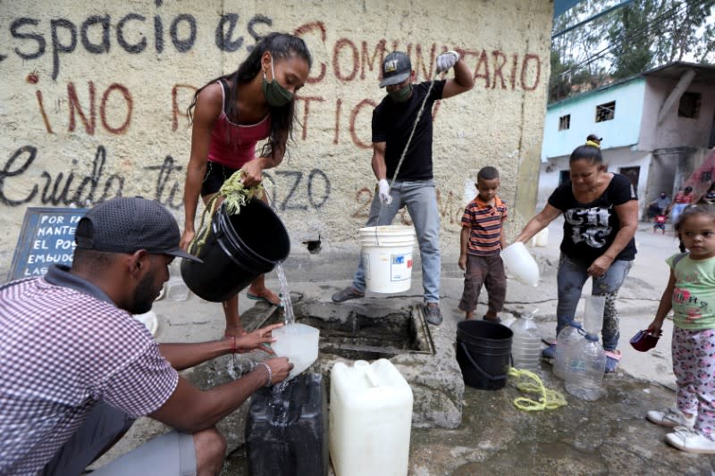 People extract water from an unknown source in the low-income neighbourhood of Petare amid the coronavirus disease (COVID-19) outbreak in Caracas