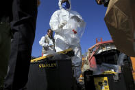 CORRECTS DAY TO TUESDAY -- Experts investigate a toxic gas explosion in Jordan's Red Sea port of Aqaba, Tuesday, June 28, 2022. A crane loading chlorine tanks onto a ship on Monday dropped one of them, causing an explosion of toxic yellow smoke that killed over a dozen people and sickened some 250, authorities said. (AP Photo/Raad Adayleh)