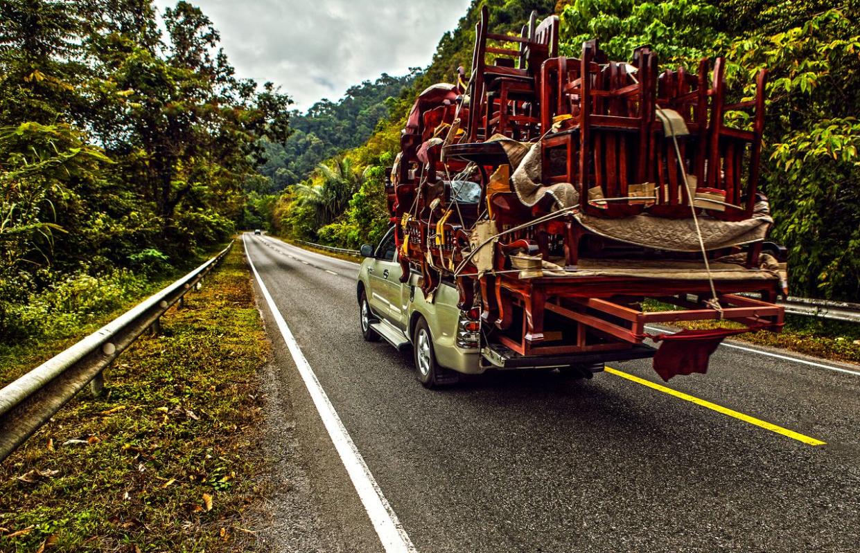 Pickup overloaded with house utensils moves on the mountain road
