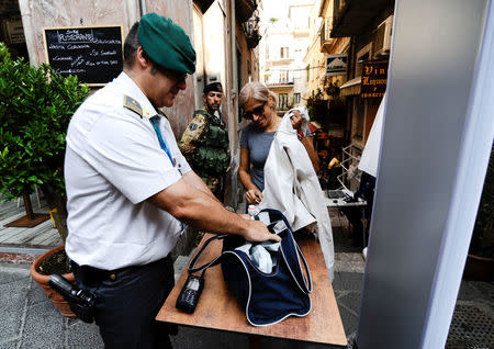 An Italian Guardia di Finanza officer checks the bag of a woman in Taormina where leaders from the world's major Western powers will hold their annual summit, Italy, May 24, 2017. REUTERS/Guglielmo Mangiapane