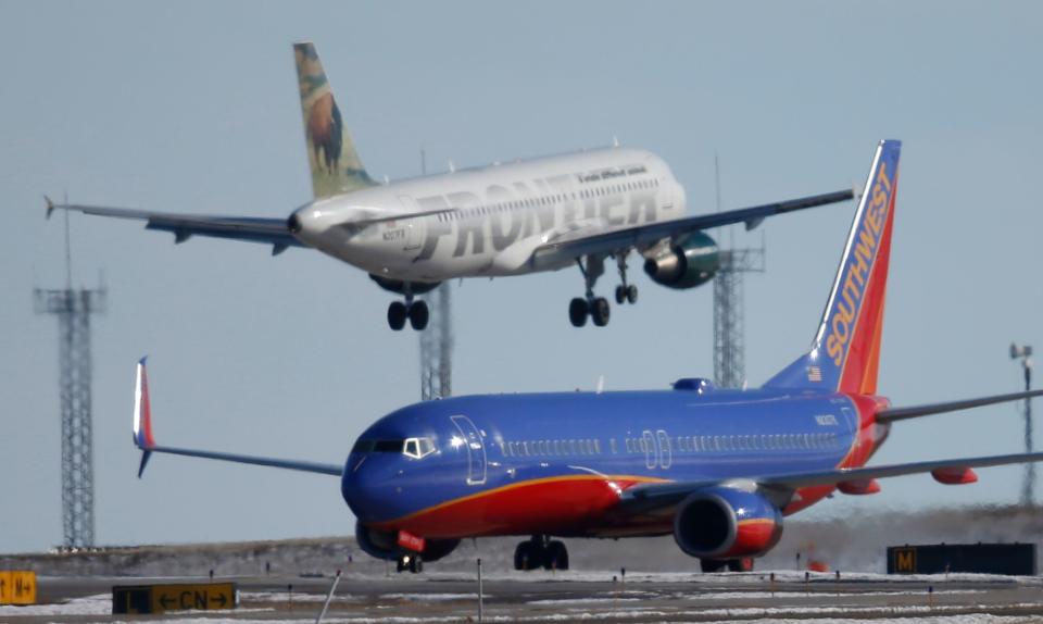 A Southwest Airlines plane waits to take off as a Frontier