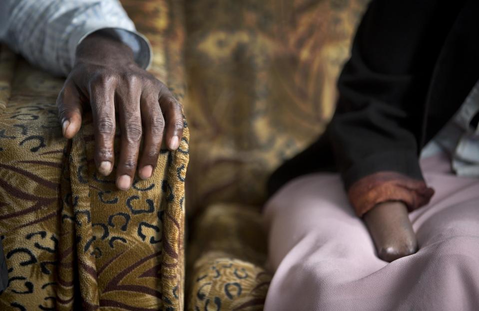 In this photo taken Wednesday, March 26, 2014, Emmanuel Ndayisaba, left, and Alice Mukarurinda, recount their experiences of the Rwandan genocide at Alice's house in Nyamata, Rwanda. She lost her baby daughter and her right hand to a manic killing spree. He wielded the machete that took both. Yet today, despite coming from opposite sides of an unspeakable shared past, Alice Mukarurinda and Emmanuel Ndayisaba are friends. She is the treasurer and he the vice president of a group that builds simple brick houses for genocide survivors. They live near each other and shop at the same market. Their story of ethnic violence, extreme guilt and, to some degree, reconciliation is the story of Rwanda today, 20 years after its Hutu majority killed more than 1 million Tutsis and moderate Hutus. The Rwandan government is still accused by human rights groups of holding an iron grip on power, stifling dissent and killing political opponents. But even critics give President Paul Kagame credit for leading the country toward a peace that seemed all but impossible two decades ago. (AP Photo/Ben Curtis)