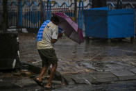 A man struggles to hold his umbrella and walk against high wind in Kolkata, India, Wednesday, May 20, 2020. Amphan, a powerful cyclone has slammed ashore along the coastline of India and Bangladesh where more than 2.6 million people fled to shelters in a frantic evacuation made all the more challenging by the coronavirus pandemic. (AP Photo/Bikas Das)