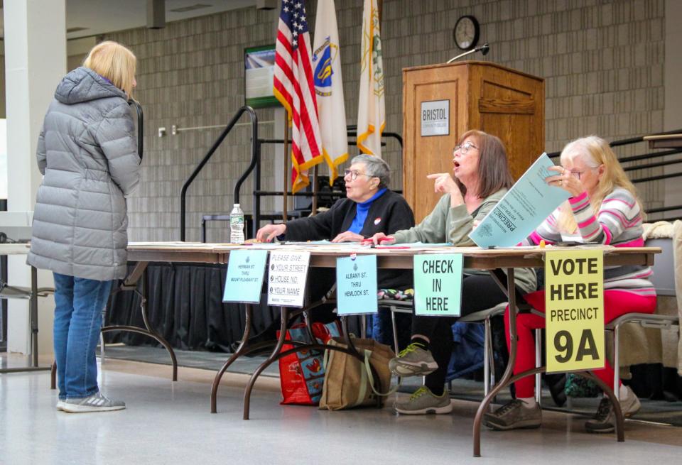 A voter checks in with staff at the Bristol Community College campus in Fall River to cast a ballot in the presidential primary on March 5, 2024.