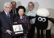 Singapore's President Tony Tan Keng Yam (L) and his wife Mary Tan are presented with a keepsake by animators Peter Lord (2nd L) and David Sproxton (R) in Bristol on October 23, 2014