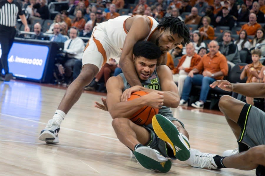 Texas guard Tyrese Hunter, back, fights for a loose ball with Baylor guard Rayj Dennis, front, during the second half of an NCAA college basketball game, Saturday, Jan. 20, 2024, in Austin, Texas. Texas won 75-73. (AP Photo/Michael Thomas)