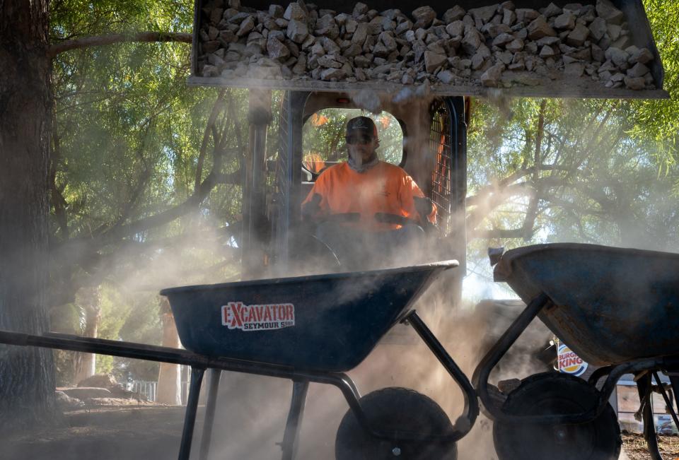 David Hernandez, of Valley Lawn Care, loads rock into a wheelbarrow for a turf conversion/removal project at The Lakes in Las Vegas, Nevada, on Sept. 26, 2022,