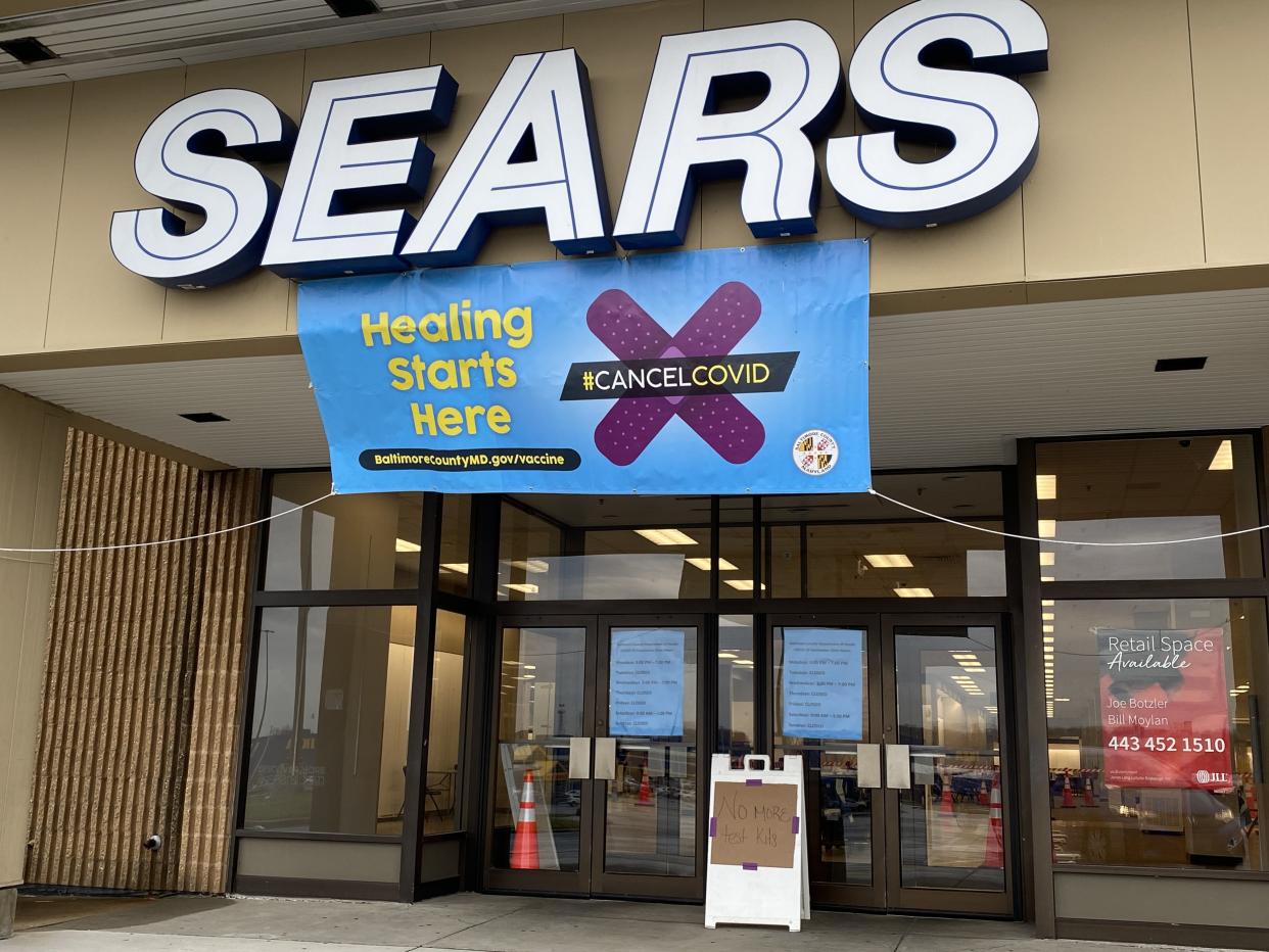 A sign advertising a Covid clinic above a Sears entrance