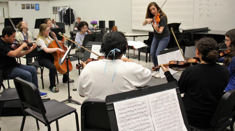 Darcy Radcliffe plays while directing her students through "Blackberry Blossom" during a rehearsal Sunday at Williams Performing Arts Center for Abilene Youth Strings, which makes its debut Monday at the Paramount Theatre.
