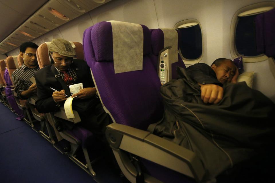 Passengers rest in their seats onboard Malaysia Airlines Boeing 777-200ER flight MH318 shortly after take off on route to Beijing