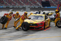 The pit crew for Joey Logano (22) scramble around the car on a pit stop during a NASCAR Cup Series auto race at Phoenix Raceway, Sunday, Nov. 8, 2020, in Avondale, Ariz. (AP Photo/Ralph Freso)