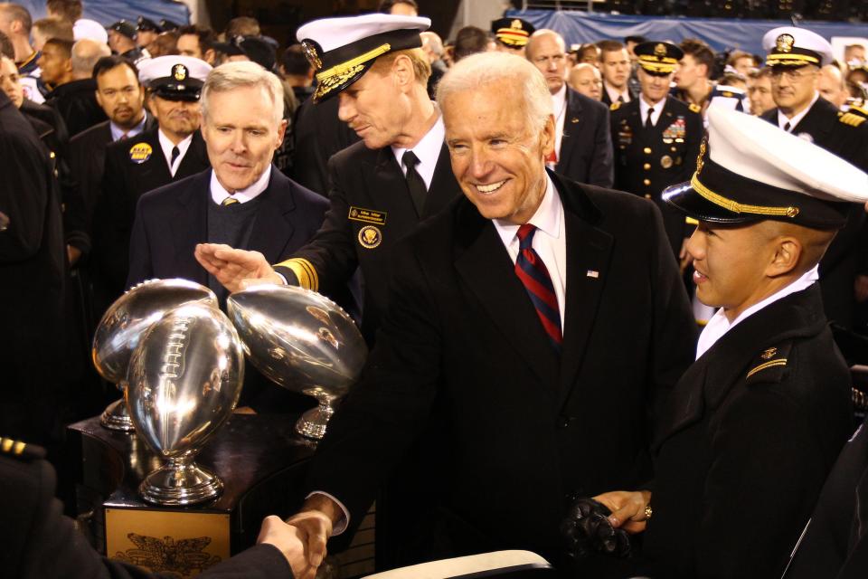 Joe Biden, then vice president of the United States, shakes hands next to the Commander-in-Chief's Trophy after Navy beat Army 17-13 in Philadelphia in 2012. DANNY WILD/USA TODAY Sports