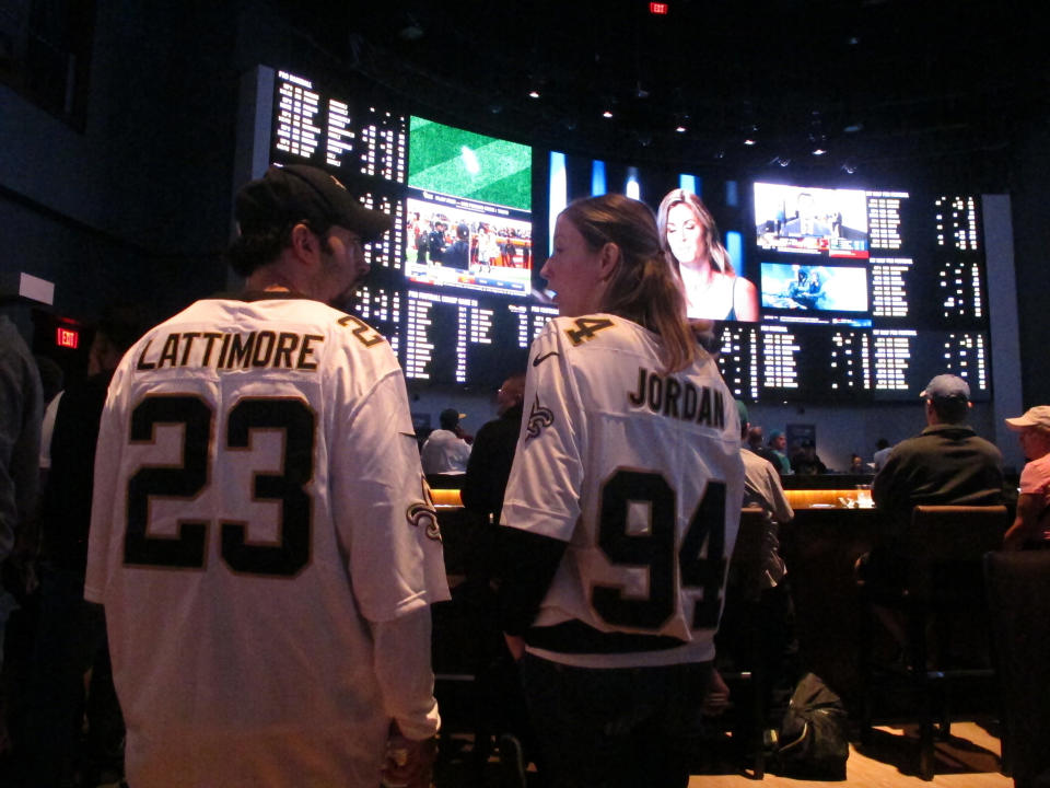 FILE - Football fans wait for kickoff in the sports betting lounge at the Ocean Casino Resort in Atlantic City, N.J., Sept. 9, 2018. Gambling has gone from the forbidden topic in the NFL to a key part of the league's present and future. The days of lobbying against widespread legalized sports betting, preventing broadcast partners from even discussing point spreads and even prohibiting players from holding a fantasy football convention because it was at a casino are firmly in the past. (AP Photo/Wayne Parry, File)