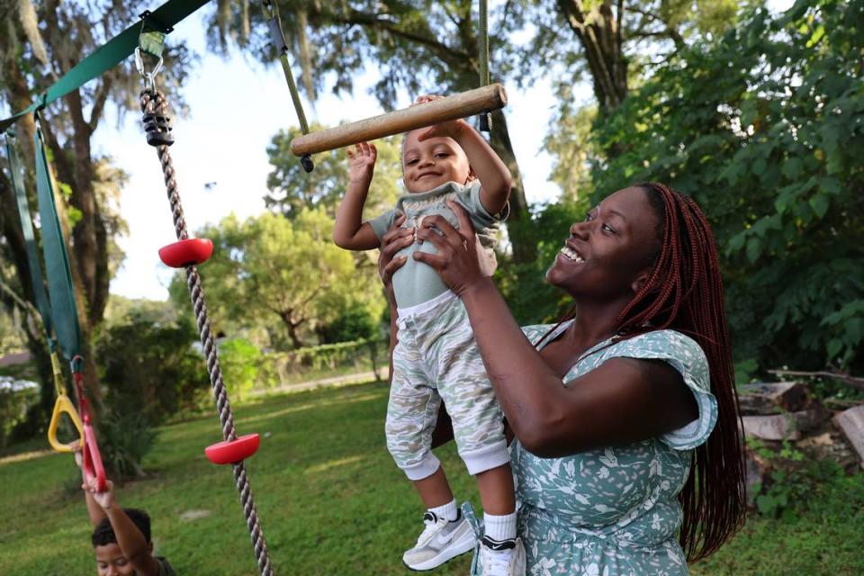 Jasmine Brown plays with her youngest son, Elijah, in the backyard of her home in Marion County, Fla., Thursday, Oct. 5, 2023.