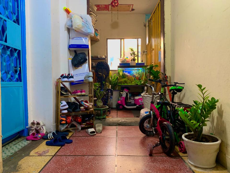 A busy hallway decorated with plants, bicycles and a fish tank