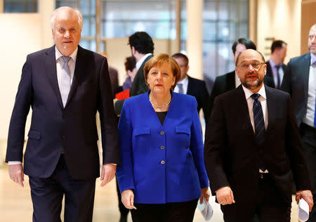 Acting German Chancellor Angela Merkel, leader of the Christian Social Union in Bavaria (CSU) Horst Seehofer and Social Democratic Party (SPD) leader Martin Schulz arrive for a press conference after exploratory talks about forming a new coalition government at the SPD headquarters in Berlin, Germany, January 12, 2018. REUTERS/Fabrizio Bensch