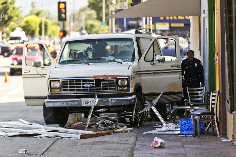 <p>An official looks into a van that plowed into a group of people on a Los Angeles sidewalk on Sunday, July 30, 2017. A witness to the crash told The Associated Press the van jumped a curb and careened into a group of people eating outside The Fish Spot restaurant in the city’s Mid-Wilshire neighborhood. The cause of the crash is under investigation. (AP Photo/Damian Dovarganes) </p>