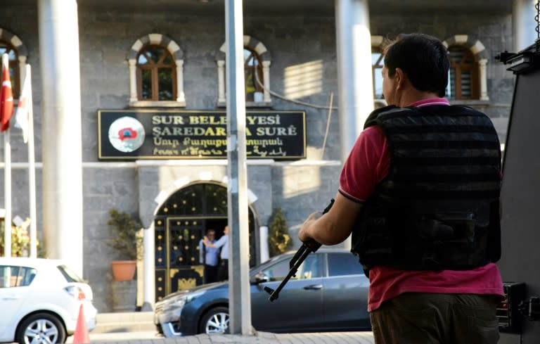 A Turkish policeman stands guard at the Sur municipality building during a police operation