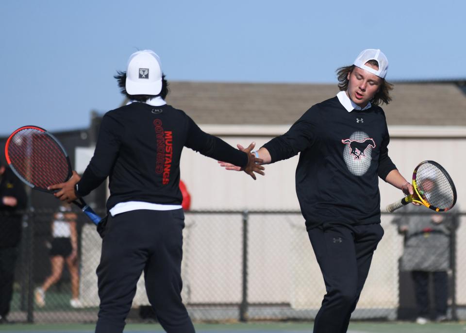 Coronado's Thomas Mann, right, and Daniel Warraich celebrate a point in the boys doubles final of the District 4-5A tennis tournament March 29 at Lubbock-Cooper High School.