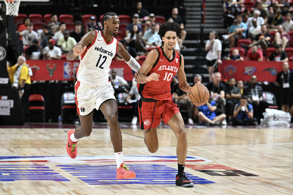 LAS VEGAS, NEVADA - JULY 12: Zaccharie Risacher #10 of the Atlanta Hawks dribbles past Alex Sarr #12 of the Washington Wizards in the second half of a 2024 NBA Summer League game at the Thomas & Mack Center on July 12, 2024 in Las Vegas, Nevada. The Wizards defeated the Hawks 94-88. NOTE TO USER: User expressly acknowledges and agrees that, by downloading and or using this photograph, User is consenting to the terms and conditions of the Getty Images License Agreement. (Photo by Candice Ward/Getty Images)