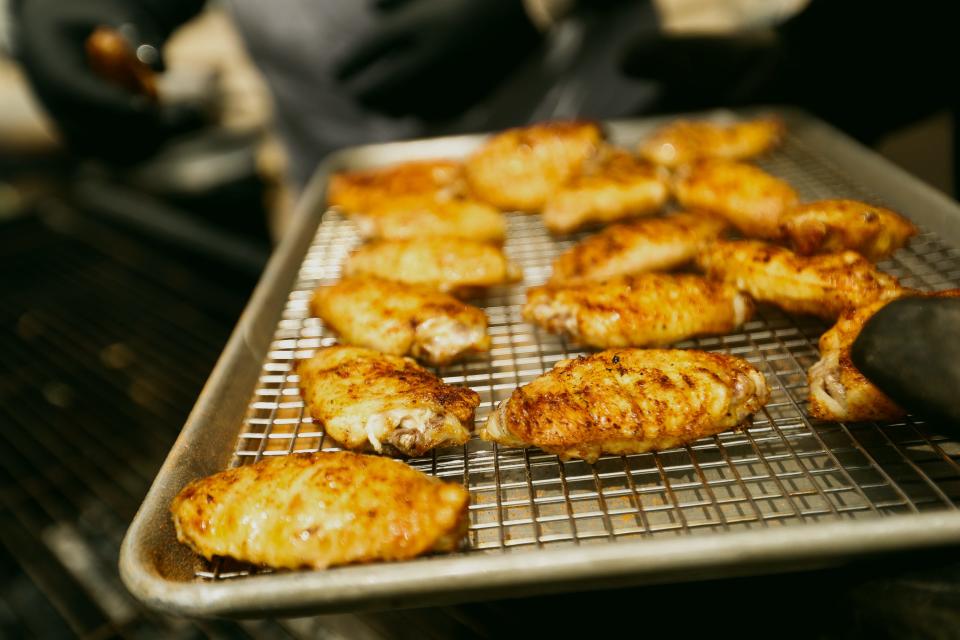 The “Flavors of South Africa” team takes its wings off the grill at its booth at the 22nd Annual World Championship Hot Wing Contest and Festival on Saturday, April 20, 2024, at River Garden Park in Memphis, Tenn.