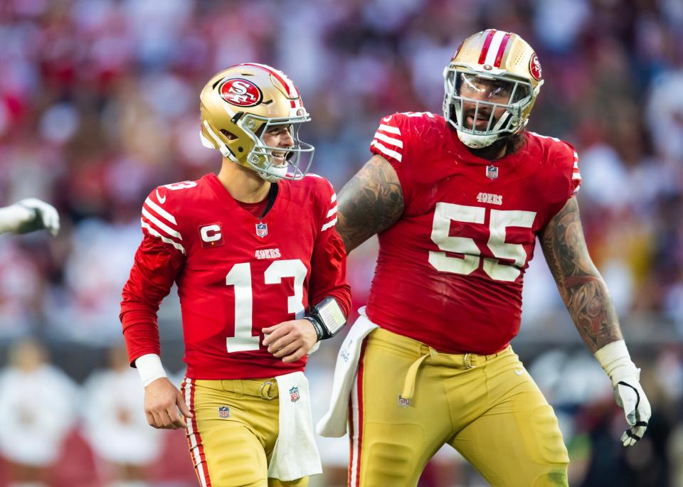 San Francisco 49ers quarterback Brock Purdy (13) celebrates a touchdown with guard Jon Feliciano (55) against the Arizona Cardinals at State Farm Stadium.