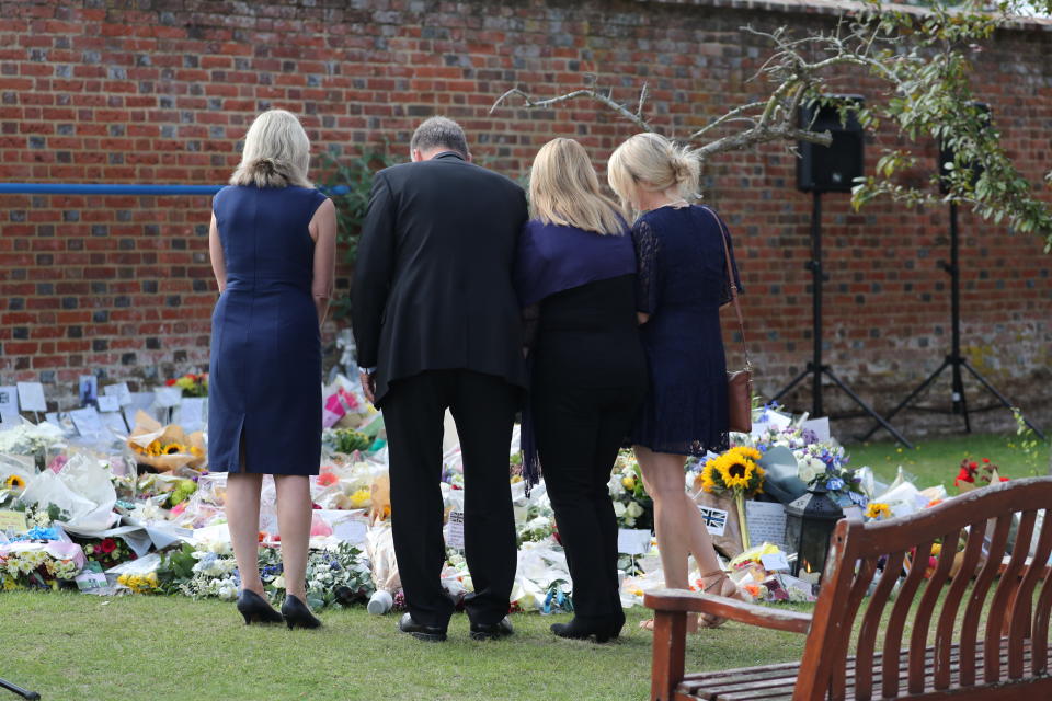 READING, ENGLAND - AUGUST 23: Family members look at floral tributes following a minute's silence for PC Andrew Harper at the Thames Valley Police Training Centre on August 23, 2019 in Sulhamstead near Reading, United Kingdom. PC Harper was killed on August 15 on the A4 near Reading and ongoing investigations have resulted in Jed Foster, 20, being accused of causing his death. Mr Foster has denied any involvement in PC Harper's death, but has yet to enter a plea at court. (Photo by Steve Parsons - WPA Pool/Getty Images)