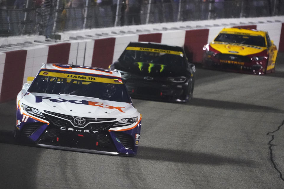 Denny Hamlin (11) leads Kurt Busch (1) and Joey Logano (22) into turn one during the NASCAR Cup series auto race in Richmond, Va., Saturday, Sept. 11, 2021. (AP Photo/Steve Helber)