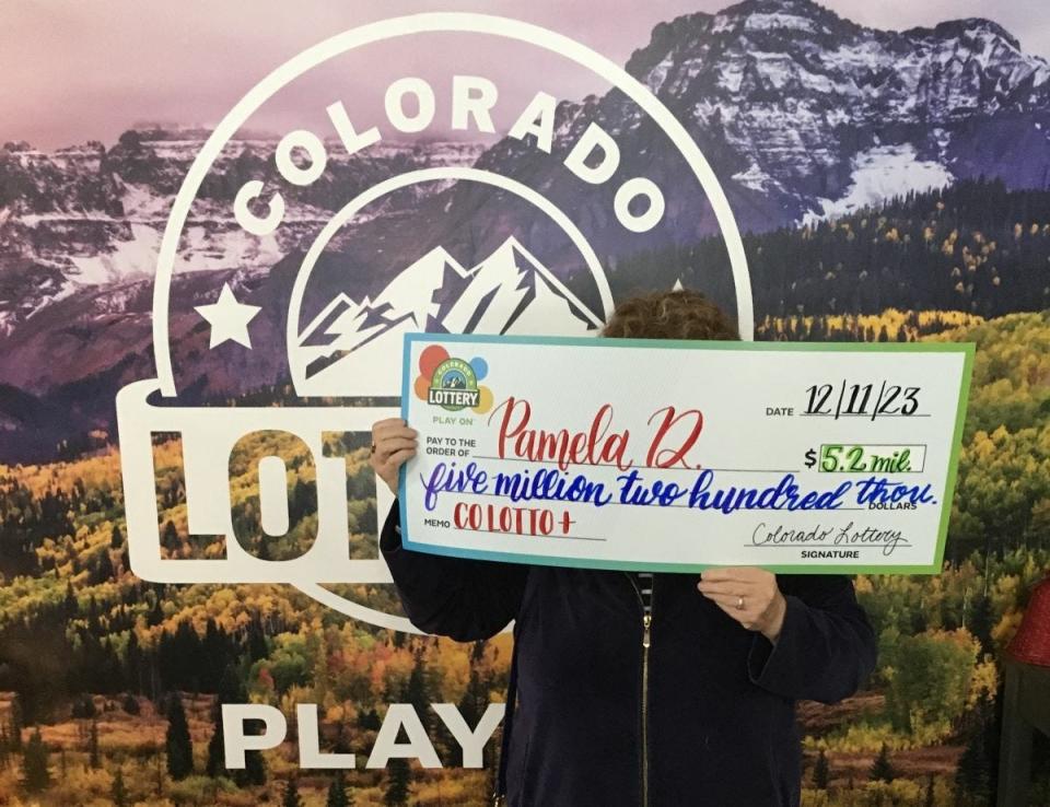 Pueblo retiree Pamela D. holds up a $5.2 million check from the Colorado Lottery after hitting the Colorado Lotto+ jackpot on a ticket she purchased Nov. 29.