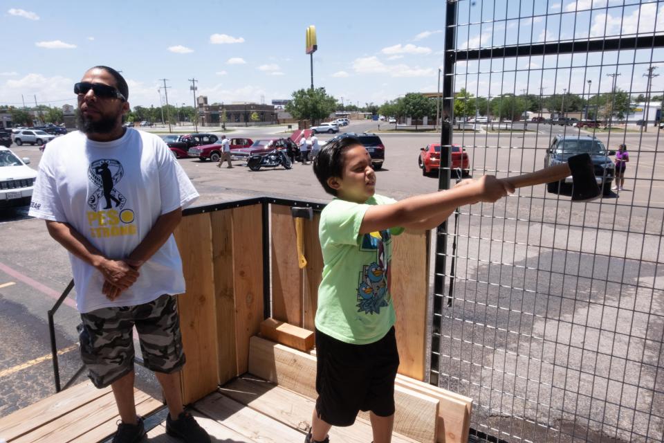 Nicasio Frausto shows his axe throwing prowess as his dad Eric stands in background Saturday during the Texas Chozen car wash fundraiser held in his honor.