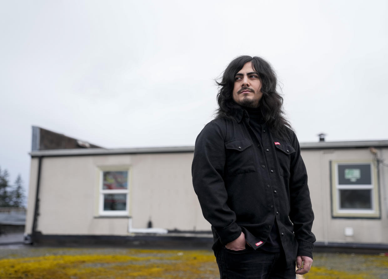 Santos Enrique Camara, who dropped out of Shoreline Community College at age 19 in 2015 after completing one semester studying audio engineering, poses for a portrait outside his home Friday, March 24, 2023, in Marysville, Wash. Camara, now 27, had difficulty paying tuition and finding time to do schoolwork while caring for his younger sister. "I seriously tried," he said. "I gave it my all." For now, Camara is happy working as a sous-chef and cook at a local restaurant while planning a tour with one of his two bands. (AP Photo/Lindsey Wasson)