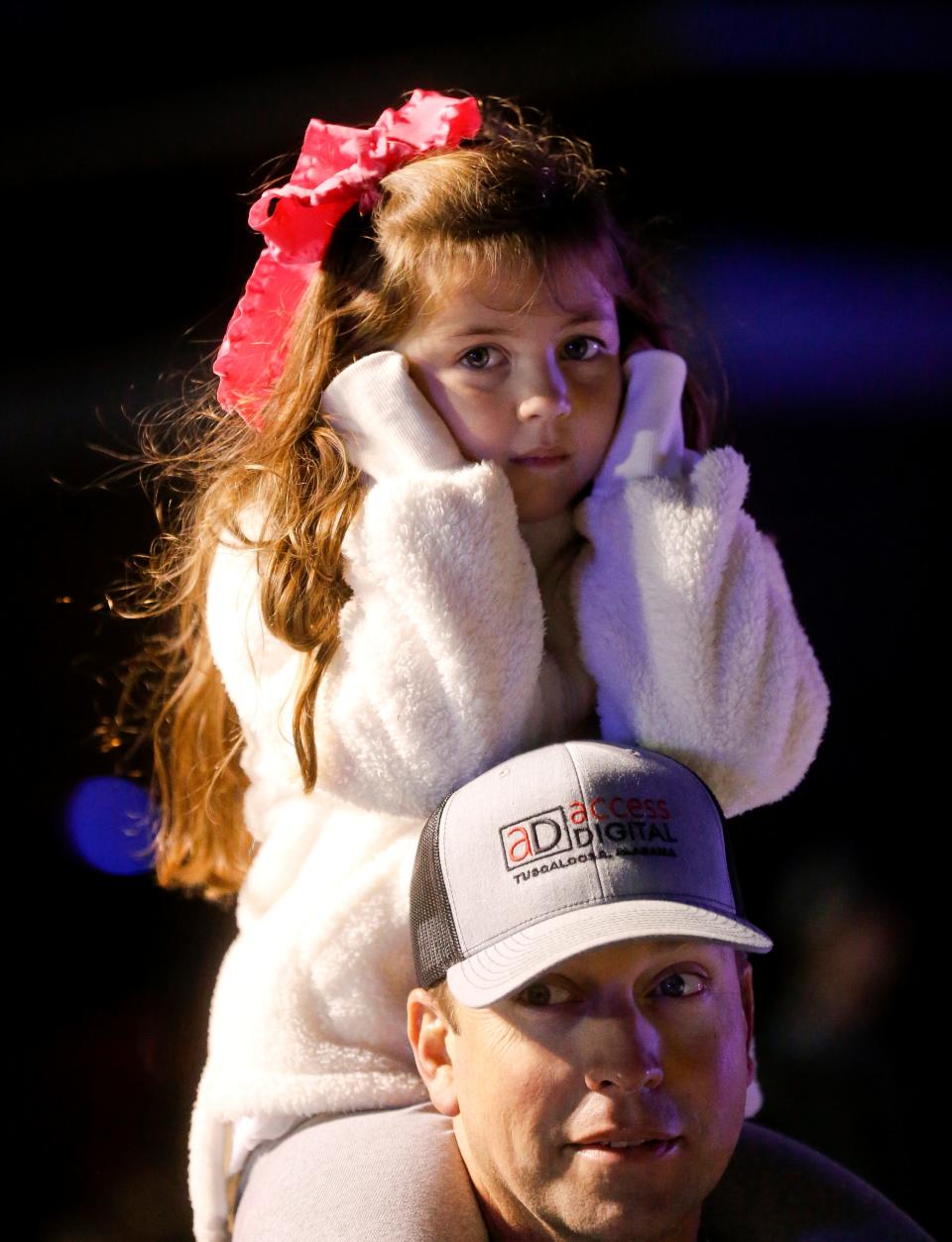 Hensley Blount sits atop her father Andrew Blount's shoulders and covers her ears as the fire trucks pass with sirens blaring in the 45th Annual West Alabama Christmas Parade. The event returned to Tuscaloosa after a year off due to COVID-19 restrictions. The theme of the 2021 parade was “Super Heroes Celebrate Christmas.” [Staff Photo/Gary Cosby Jr.]