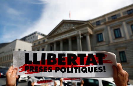 A person holds a placard reading "Freedom for political prisoners!" outside the Spanish Parliament, in Madrid, Spain, May 20, 2019. REUTERS/Juan Medina