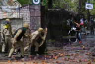 <p>A Kashmiri protester throws stones at Indian policemen as students clash with police in Srinagar, Indian controlled Kashmir, Monday, April 24, 2017. Tensions between Kashmiri students and Indian law enforcement have escalated since April 15, when government forces raided a college in Pulwama, about 30 kilometers (19 miles) south of Srinagar, to scare anti-India activists. (AP Photo/Mukhtar Khan) </p>