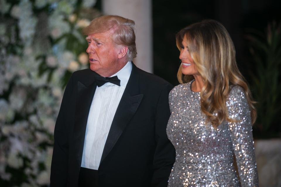 Former President Donald Trump and his wife, Melania, approach the Mar-A-Lago ballroom on New Year's Eve in Palm Beach.