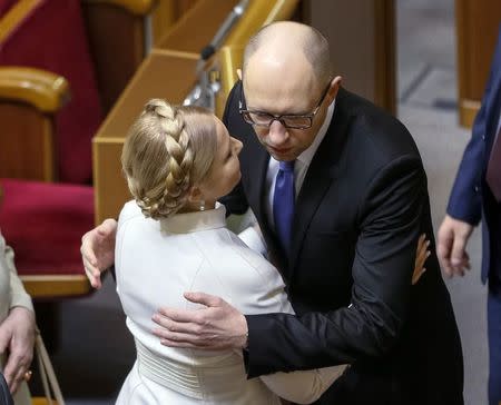 Ukrainian Prime Minister Arseny Yatseniuk (R) welcomes former Prime Minister and newly elected parliamentary deputy Yulia Tymoshenko during the first session of a new Ukrainian parliament, elected in October, in Kiev, November 27, 2014. REUTERS/Gleb Garanich