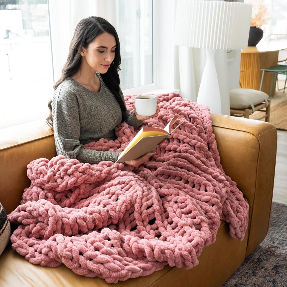 model wrapped in pink knit blanket