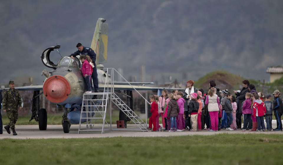 Romanian children, visiting an airbase, wait to look at a Soviet era Romanian MIG 21 fighter jet in Campia Turzii, Romania, Thursday, April 10, 2014. Some 450 U.S. and Romanian troops are taking part in the Dacian Viper 2014 joint military exercise in Transylvania, northwestern Romania flying U.S. F-16 fighter jets of the U.S. 31st Fighter Wing alongside Romanian Mig-21 Lancers.The weeklong exercise, the fourth of its kind, was planned before Russia’s recent annexation of Crimea, according to officials.(AP Photo/Vadim Ghirda)