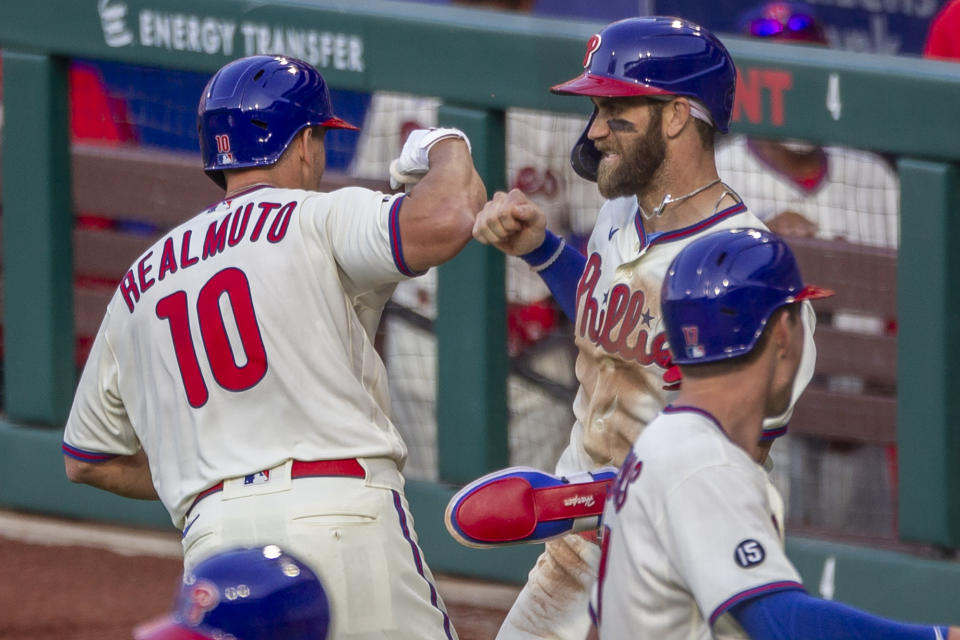Philadelphia Phillies J.T. Realmuto (10) is congratulated by Bryce Harper after hitting a three run homer during the fifth inning of a baseball game against the New York Mets, Wednesday, April 7, 2021, in Philadelphia. (AP Photo/Laurence Kesterson)