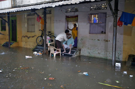 A man gets his shave done on the entrance of his house during rains in Mumbai, India, September 20, 2017. REUTERS/Shailesh Andrade