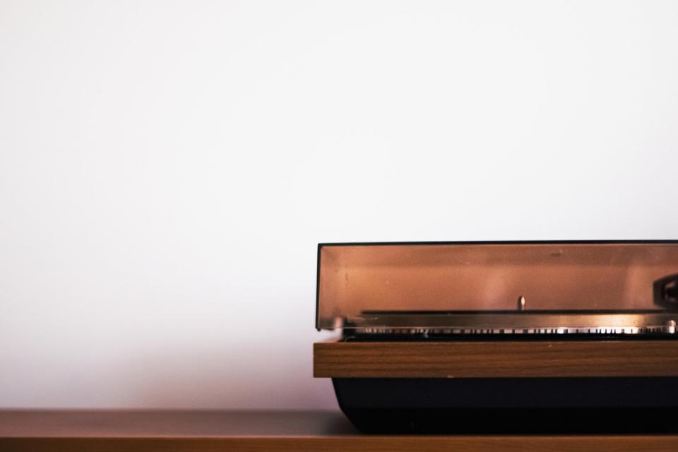 Turntable standing on the brown surface with a lot of white background