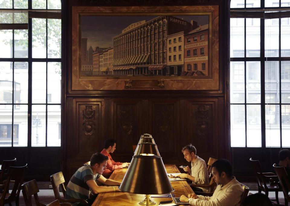 In this Monday, July 22, 2013 photo, patrons use the periodicals room at the main branch of the New York Public Library in New York. Plans for a major change within the New York Public Library’s landmark main building have kindled an intellectual culture clash over its direction and the future of libraries themselves. (AP Photo/Seth Wenig)