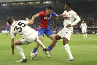 Crystal Palace's Daniel Munoz, centre, challenges for the ball with Manchester United's Jonny Evans, left, and Manchester United's Kobbie Mainoo during the English Premier League soccer match between Crystal Palace and Manchester United at Selhurst Park stadium in London, England, Monday, May 6, 2024. (AP Photo/Ian Walton)