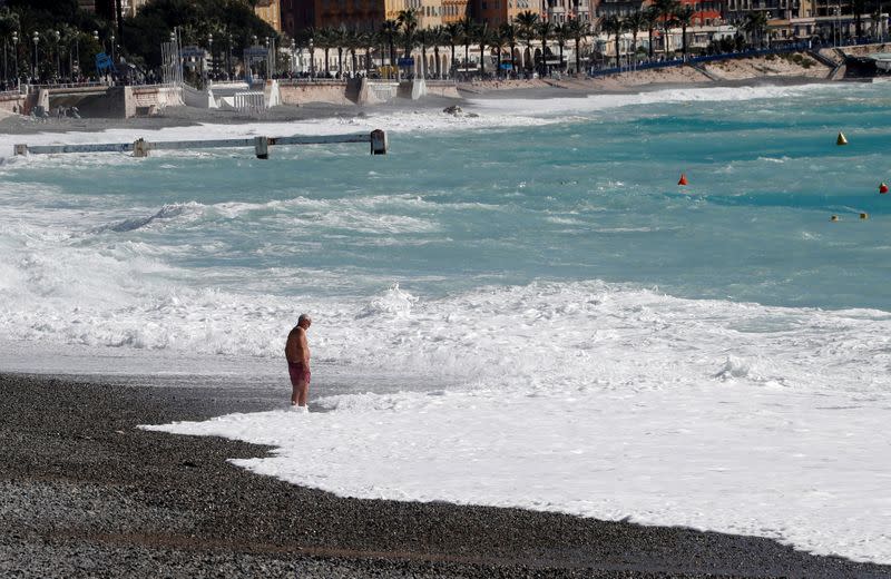 A man is seen on a beach of the Promenade des Anglais following heavy rainfall in Nice